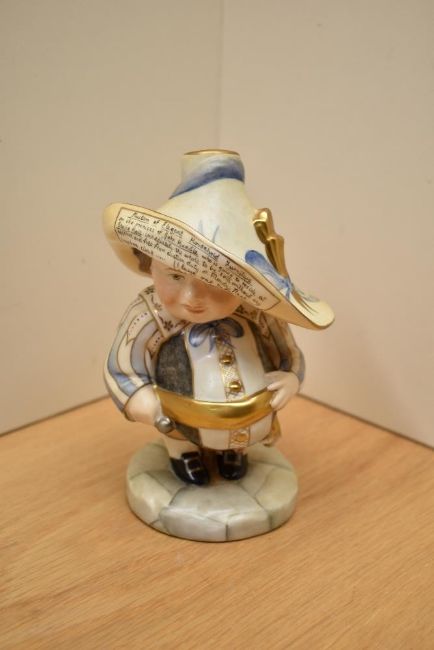 A Royal Crown Derby Millenium mansion house dwarf, marked J Griffiths to underside, measures 16cm tall.